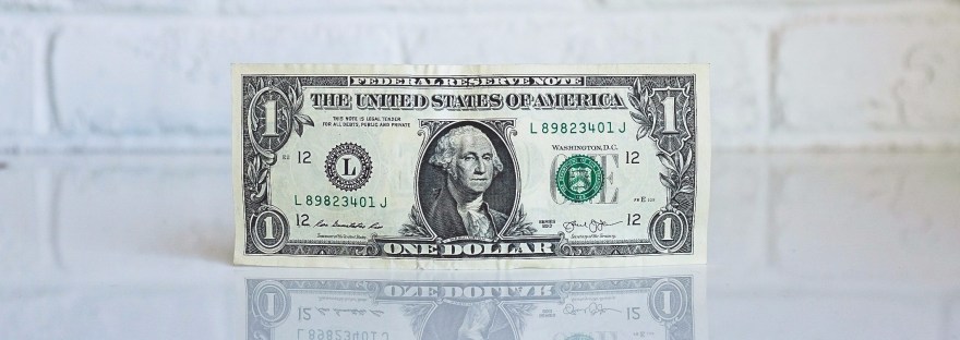 dollar bill balanced on its side