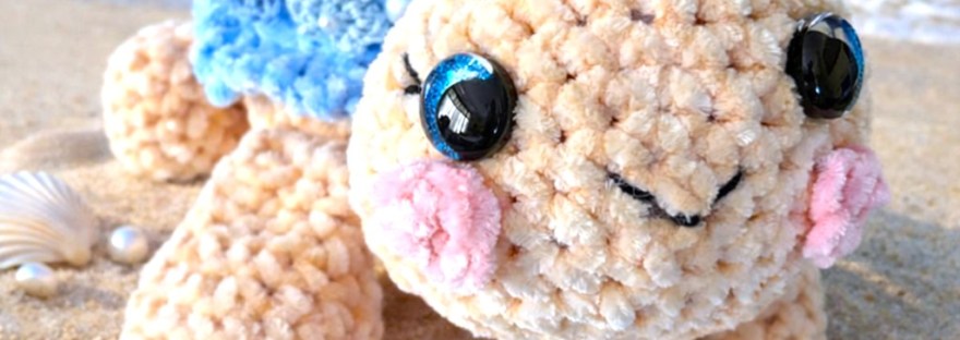 Crocheted sea little turtle with blue flowers covering her shell